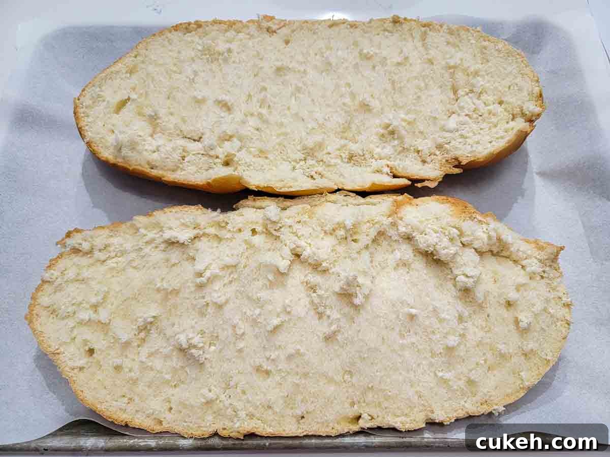 bread loaf sliced in half length wise on a baking sheet.