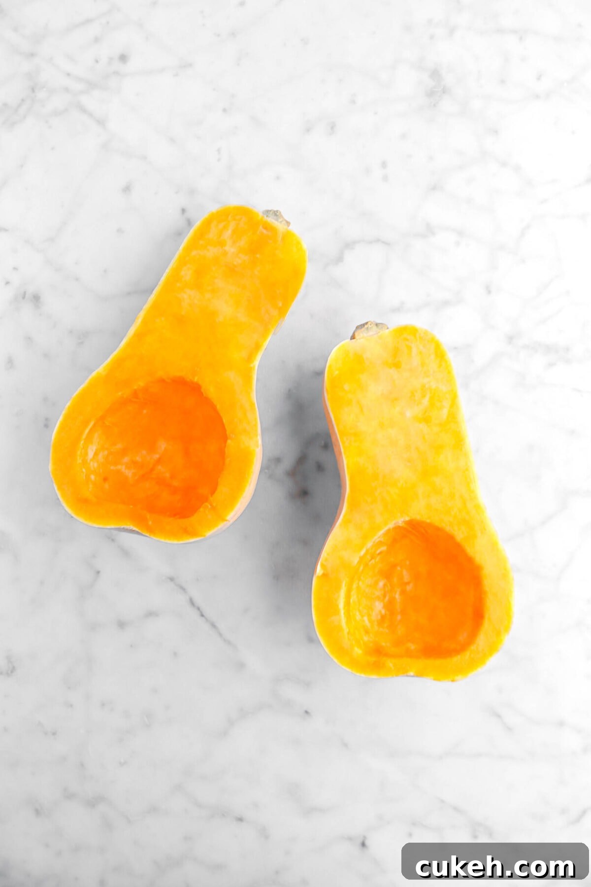 halved butternut squash on marble surface.