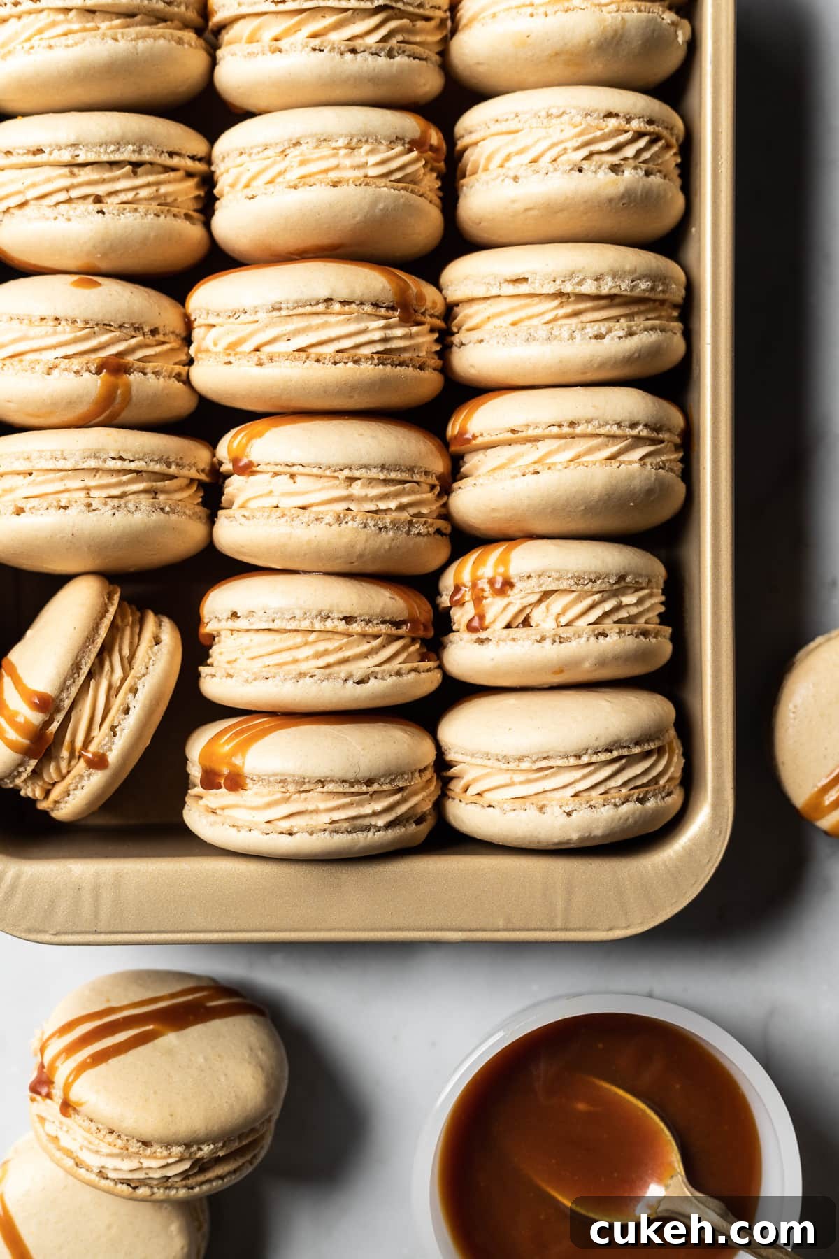 Filled macarons turned on their side to show the piped caramel buttercream.