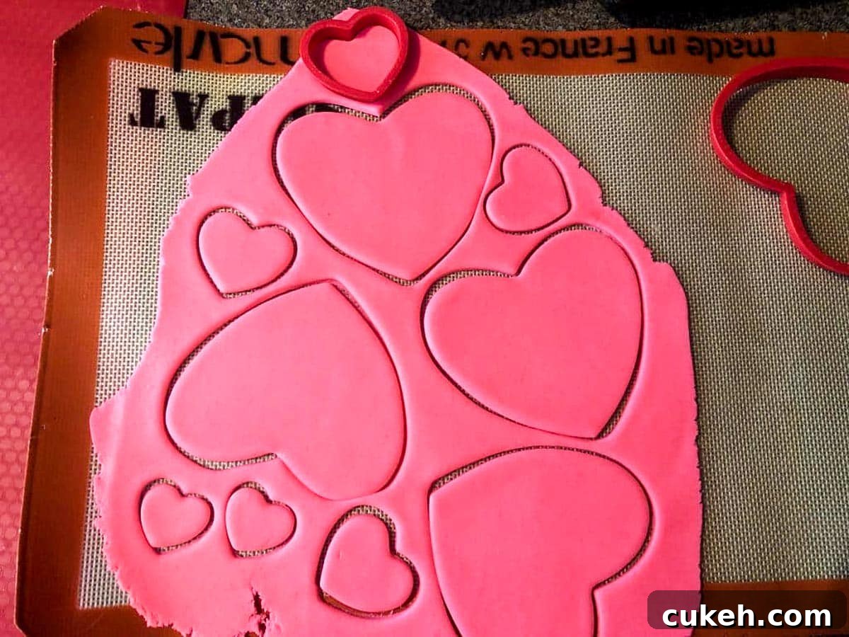 pink fondant rolled out with heart shapes cut into it