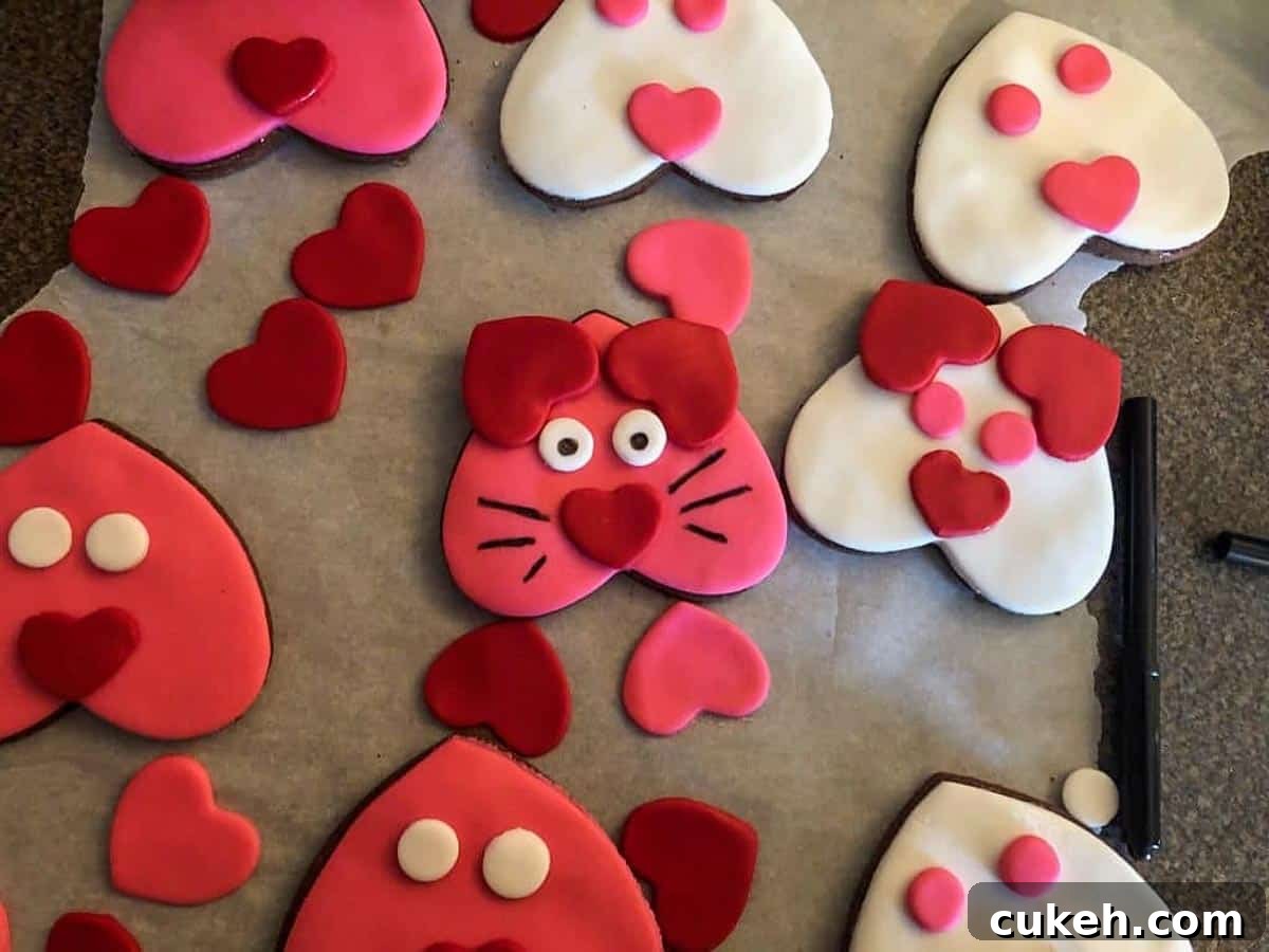 Heart-shaped cat cookies with some done (with whiskers etc)