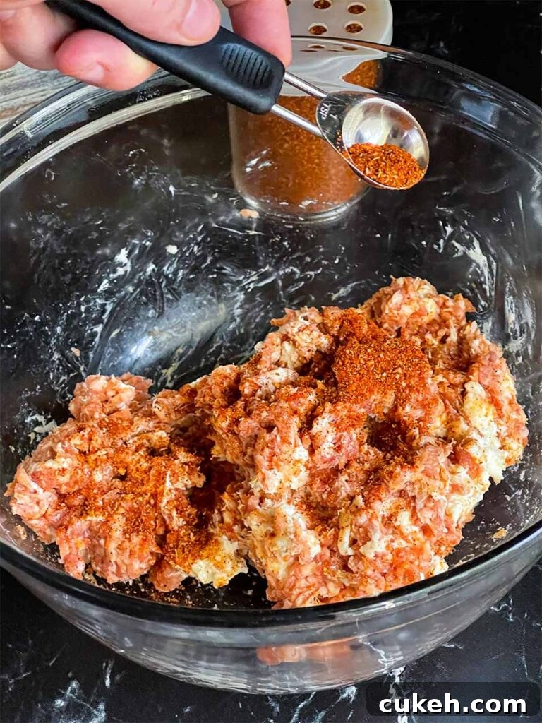 Smoked Shotgun Shells: Savory Sausage-Stuffed Appetizer Recipe 4 Adding barbecue rub to the sausage mixture in a glass bowl for the smoked shotgun shells.