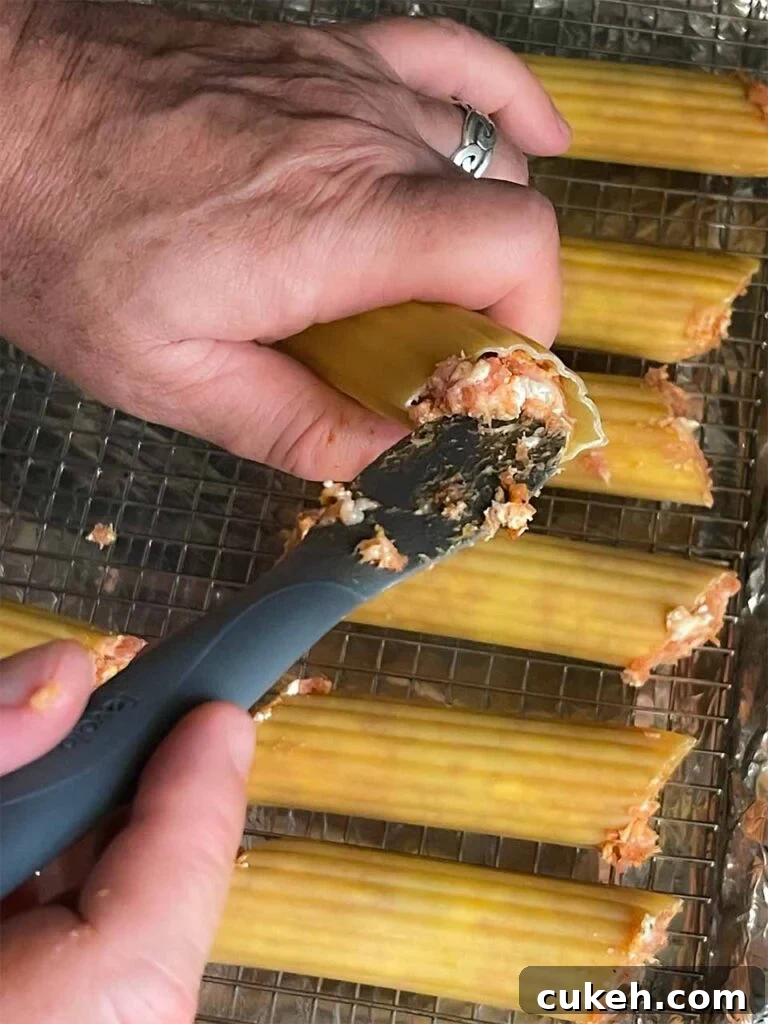 Smoked Shotgun Shells: Savory Sausage-Stuffed Appetizer Recipe 5 Stuffing the manicotti shells with the sausage mixture for smoked shotgun shells.