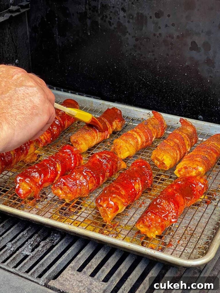 Smoked Shotgun Shells: Savory Sausage-Stuffed Appetizer Recipe 8 Applying barbecue sauce to the smoked shotgun shells.