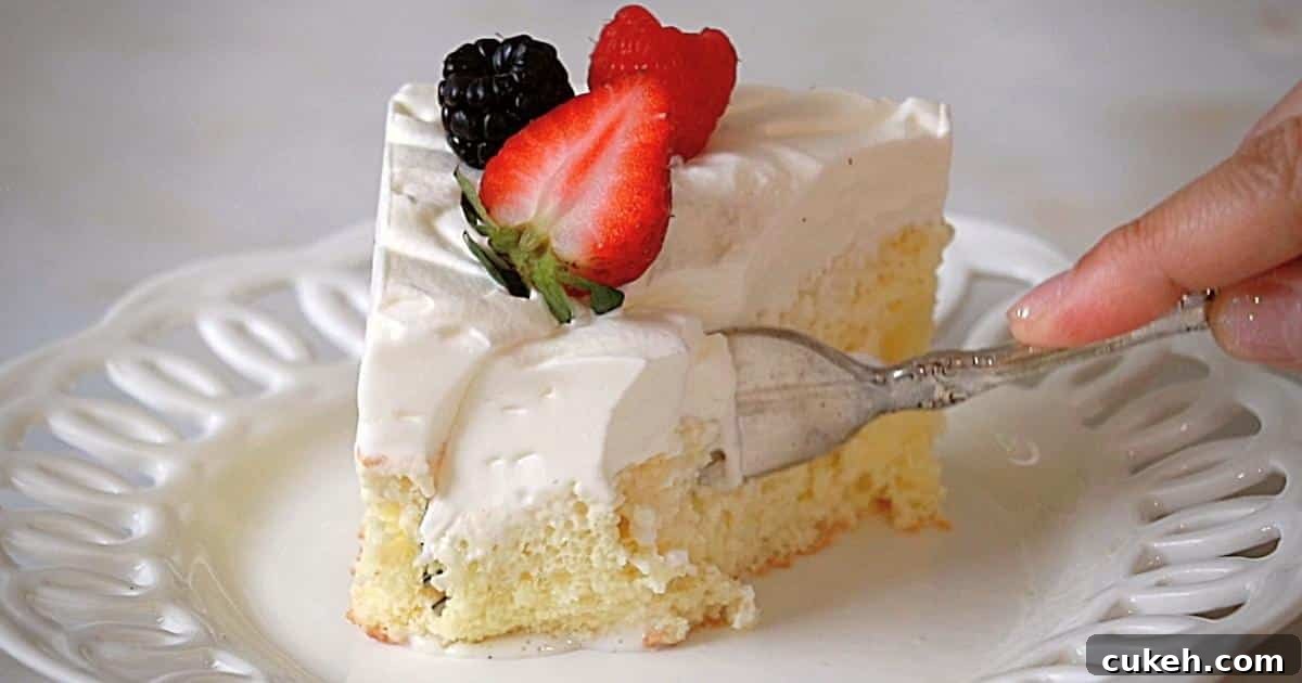 cutting tres leches cake on a white plate with a fork