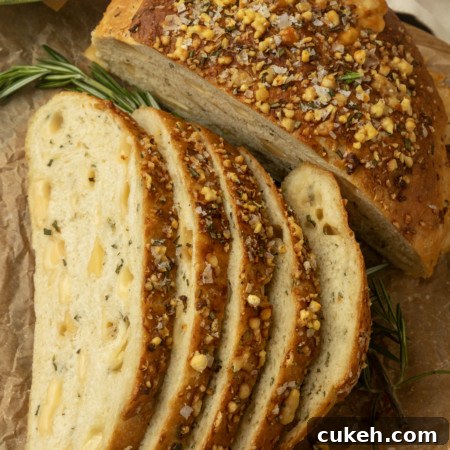 partially sliced one hour rosemary parmesan bread on parchment paper