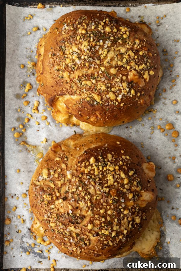 two loaves of rosemary parmesan bread on a parchment lined sheet pan