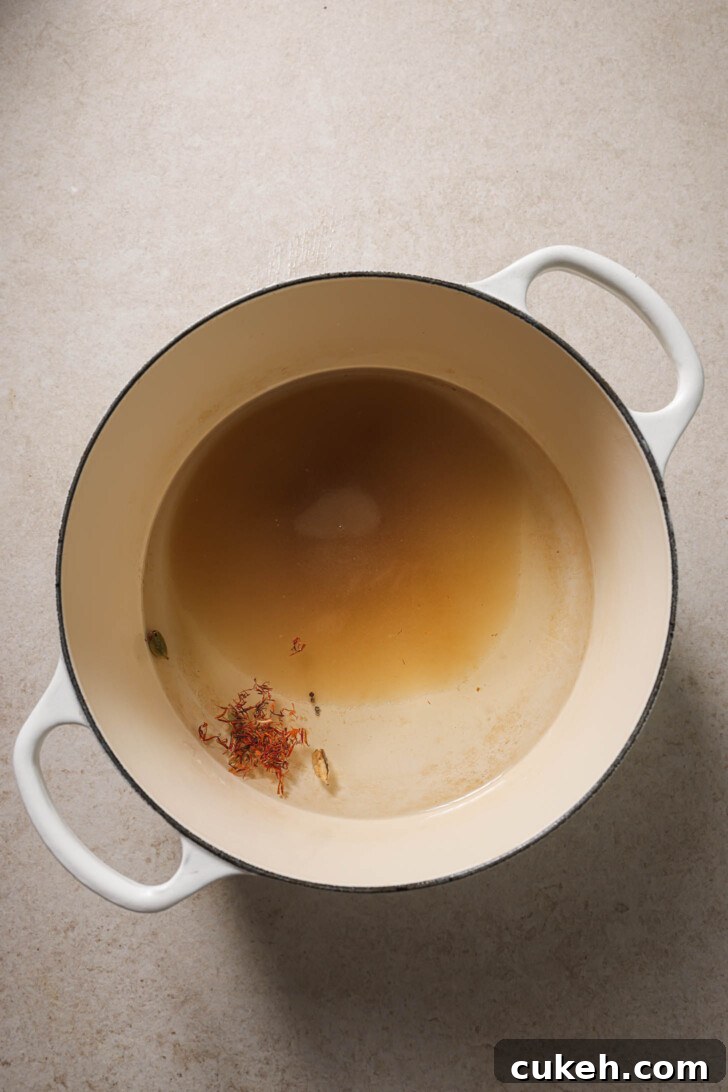 Water, sugar, cardamom pods and saffron added to a pot to make sugar syrup for Gulab Jamun.