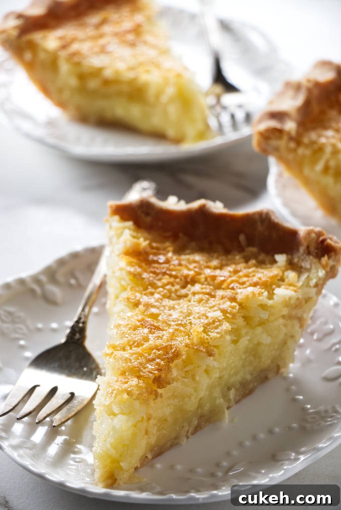 Three slices of coconut pie on dessert plates.