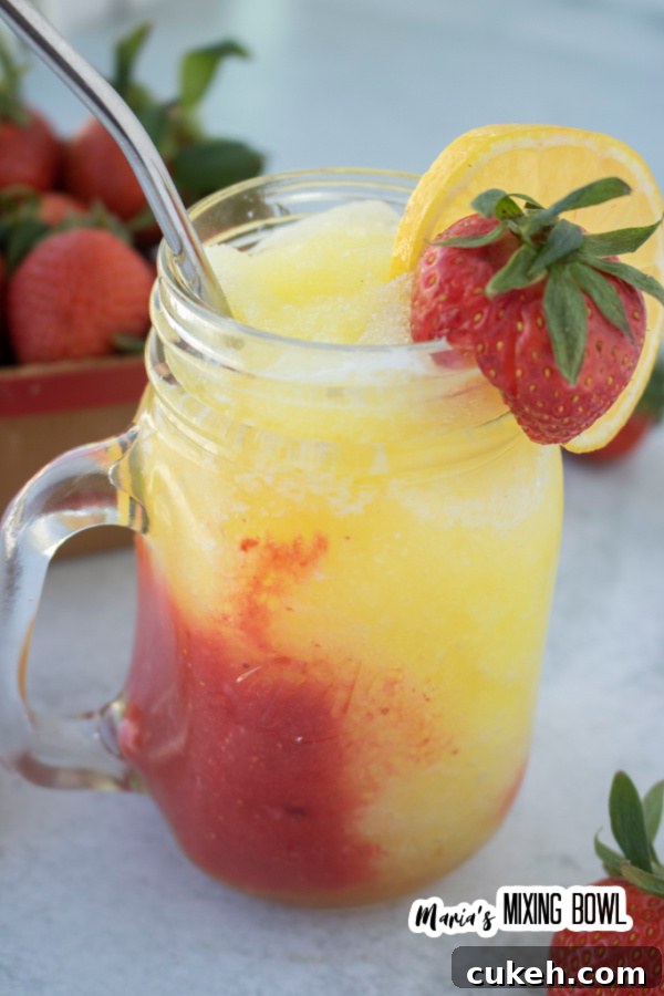 Red and yellow frozen berry lemonade in glass