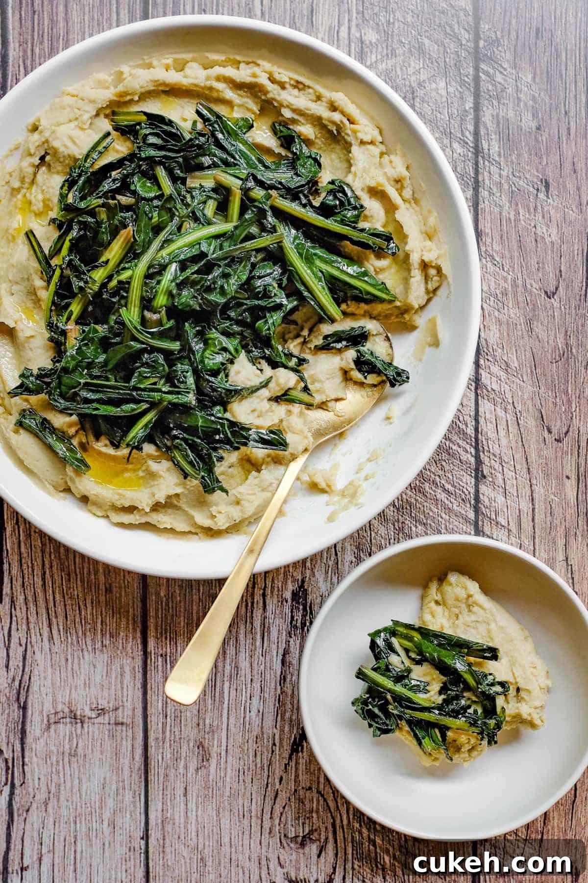 A large platter and smaller bowl with fava bean puree and bitter chicory greens