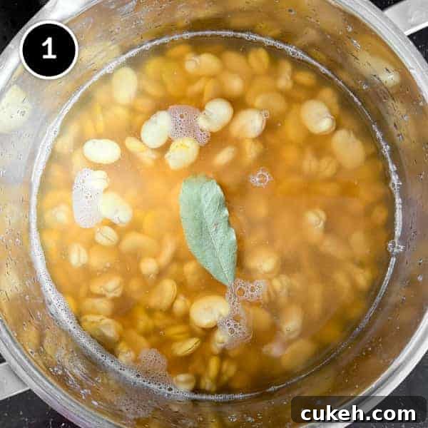 Skinned fava beans simmering in a pot.