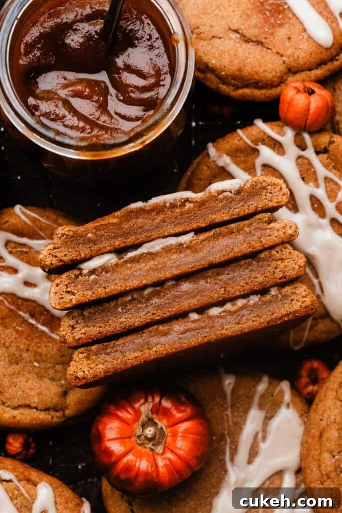 A close-up on a stack of pumpkin cookie halves, showing their chewy insides.