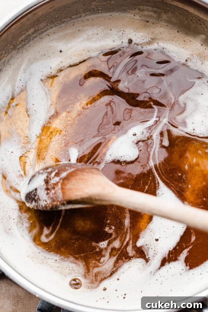 A pan of brown butter being stirred.