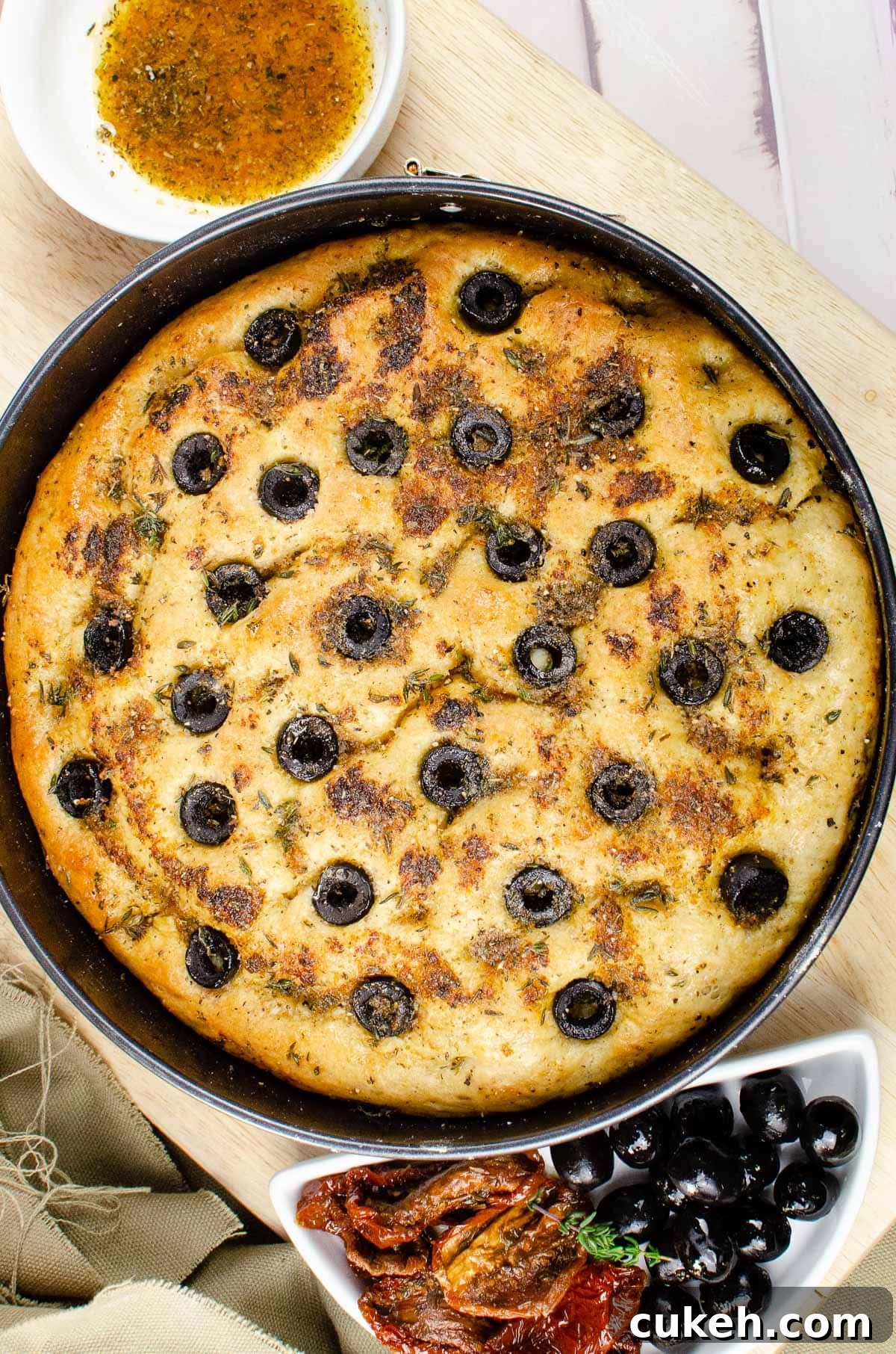 Cooked focaccia bread in a bread tin on a wooden chopping