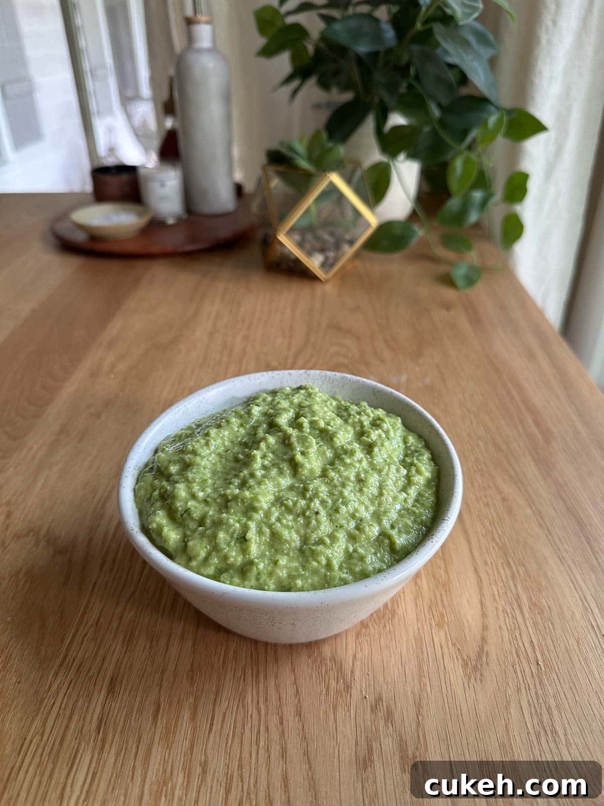 a bowl with garlic scape pesto on a table