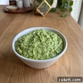 a bowl with garlic scape pesto on a table
