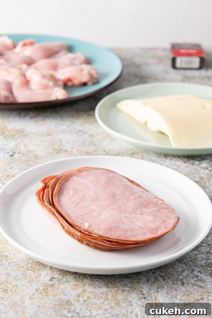 Crispy Baked Chicken Cordon Bleu Recipe for Weeknight Dinners 4 Ham, Swiss cheese and chicken on a blue plate