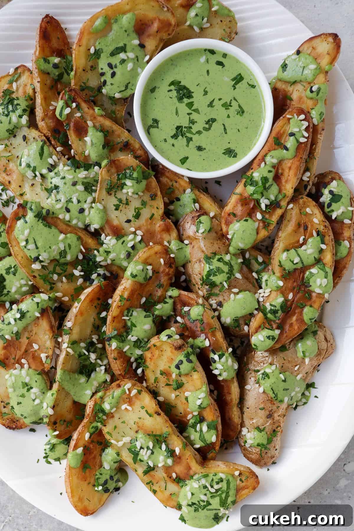 Close up of fingerling potatoes with tahini sauce and sesame seeds.