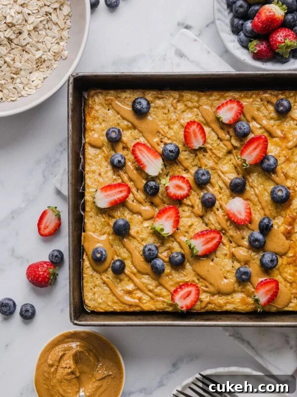Protein baked oatmeal in a pan with peanut butter and fresh berries.