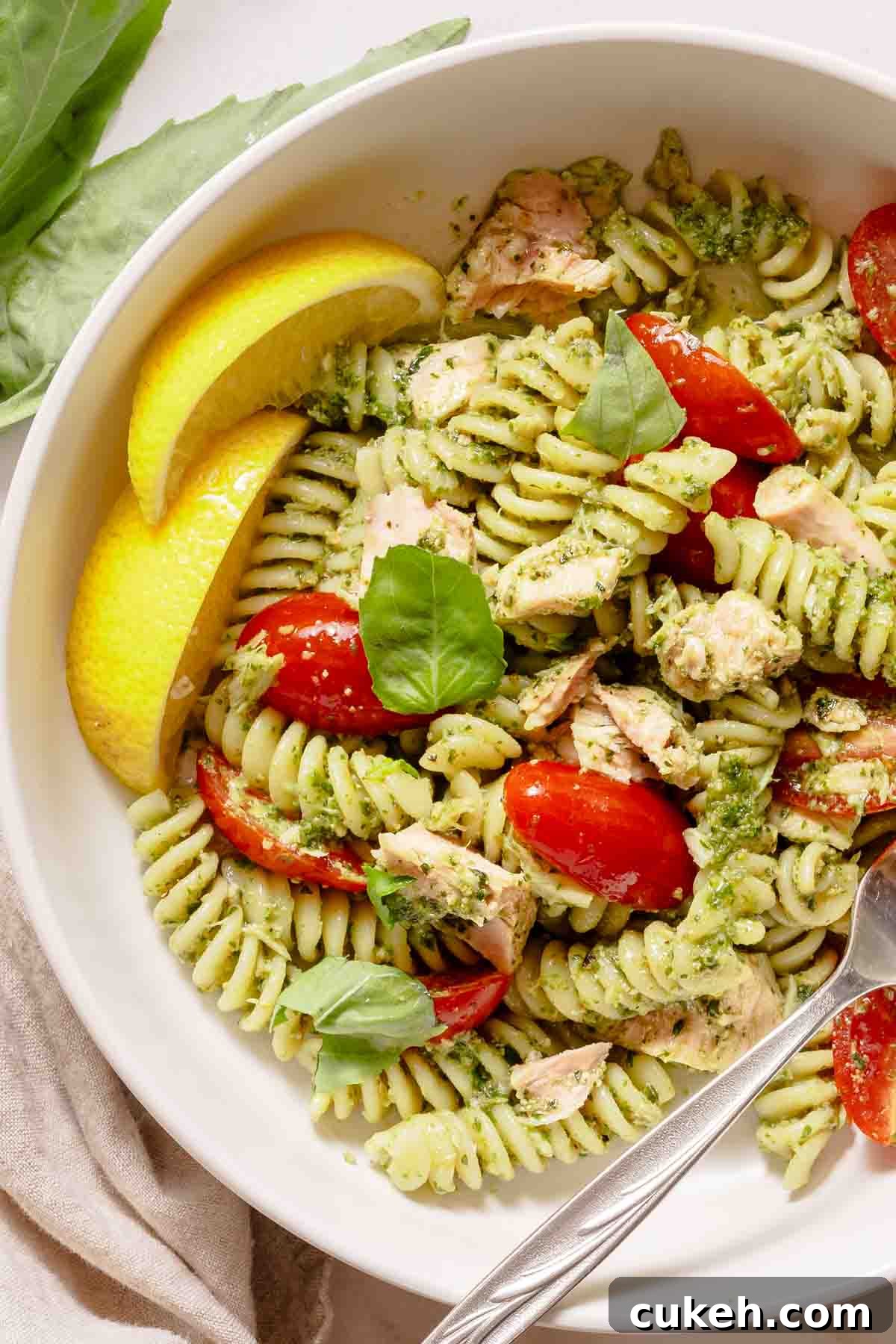 Creamy Tuna Pesto Pasta Recipe for Weeknight Dinners 2 pasta in bowl with tuna and pesto sauce and lemon on the side.