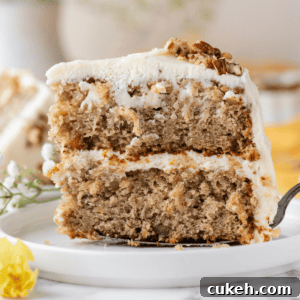 a piece of two-layer hummingbird cake being placed on a white plate with a spatula