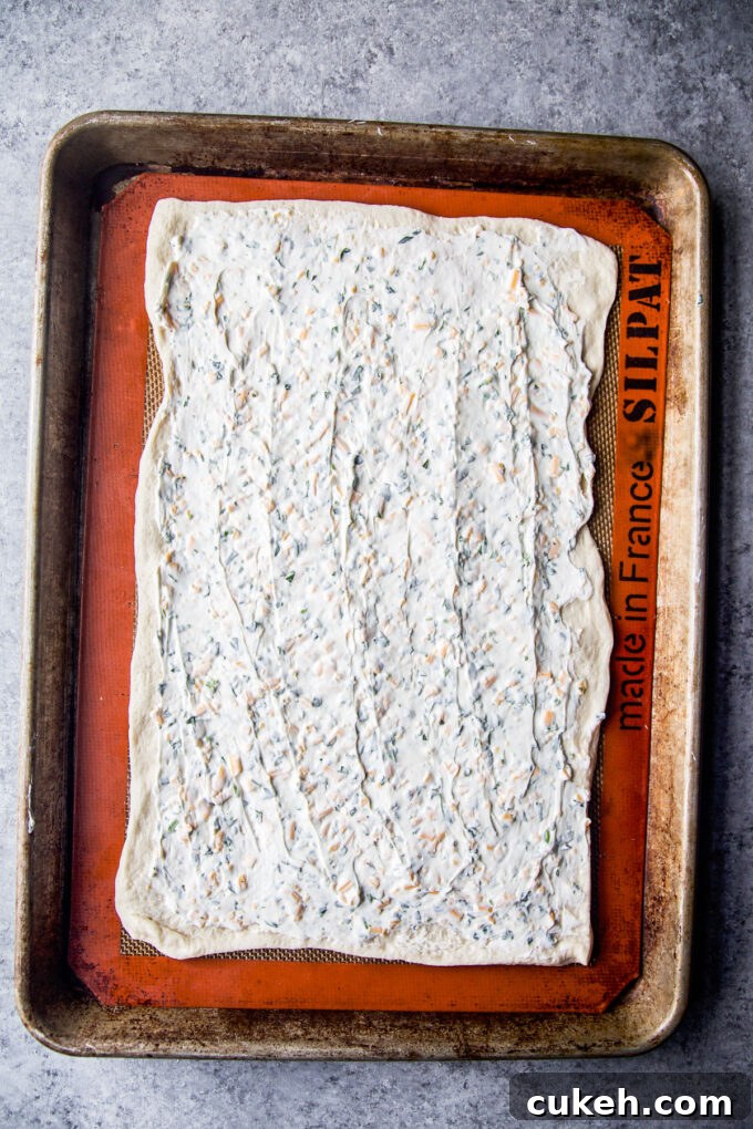 cream cheese spread on pizza dough