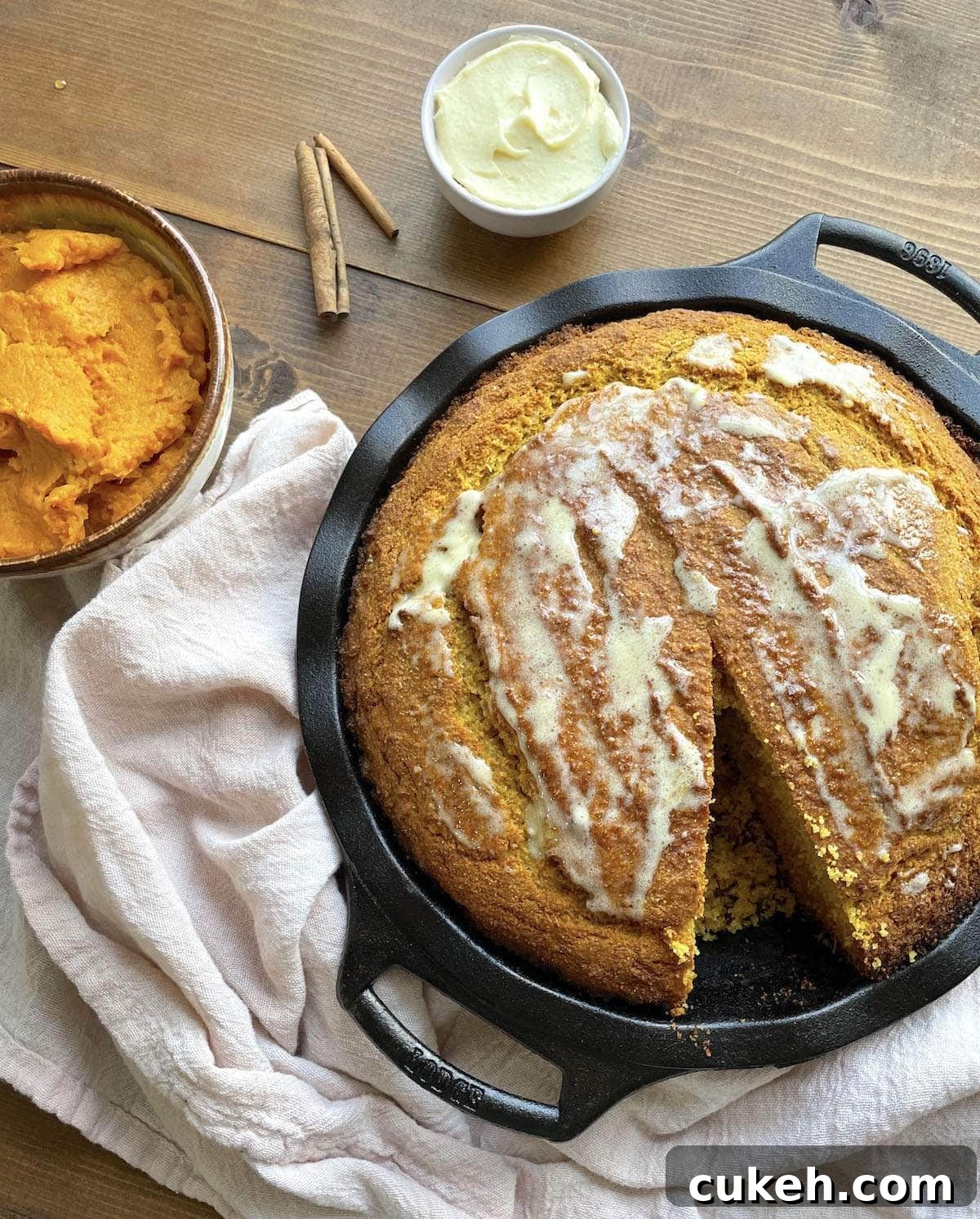 A bowl of sweet potato cornbread with honey butter spread on top.