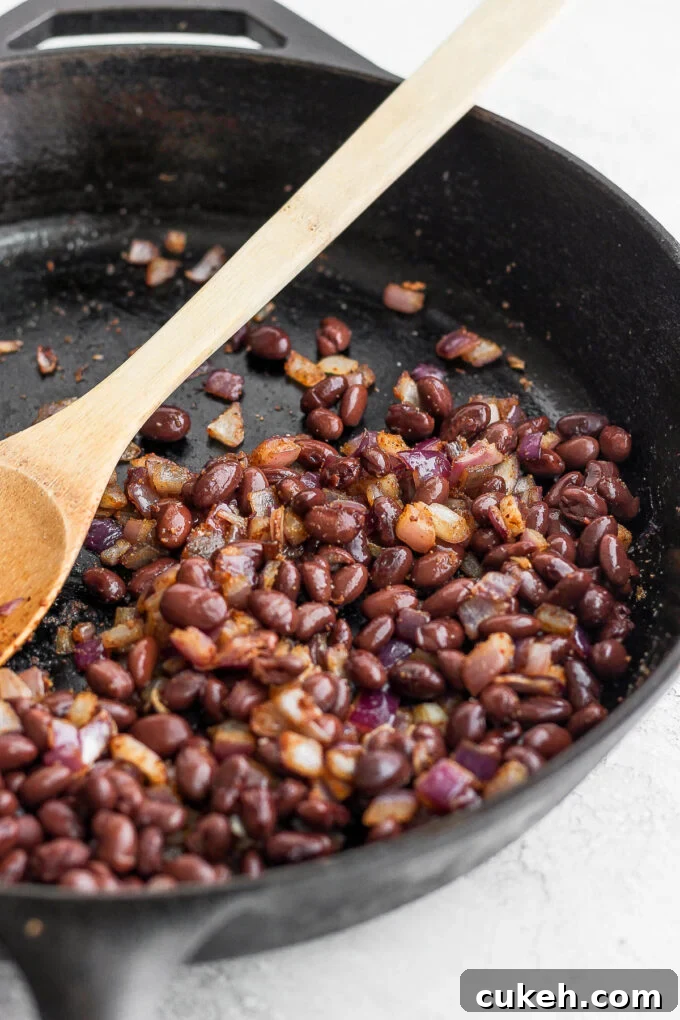 sauteed black beans and onion in a skillet
