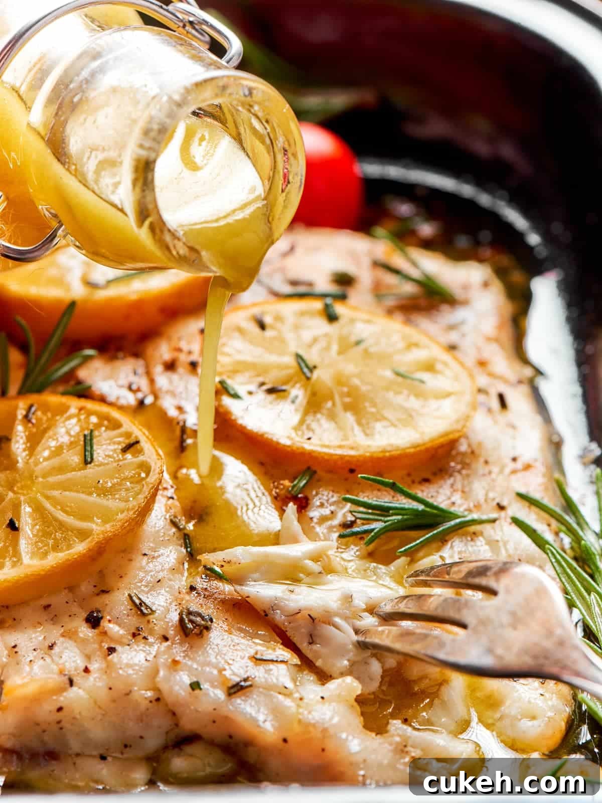 Champagne vinaigrette poured onto baked halibut while holding a fork on tray.