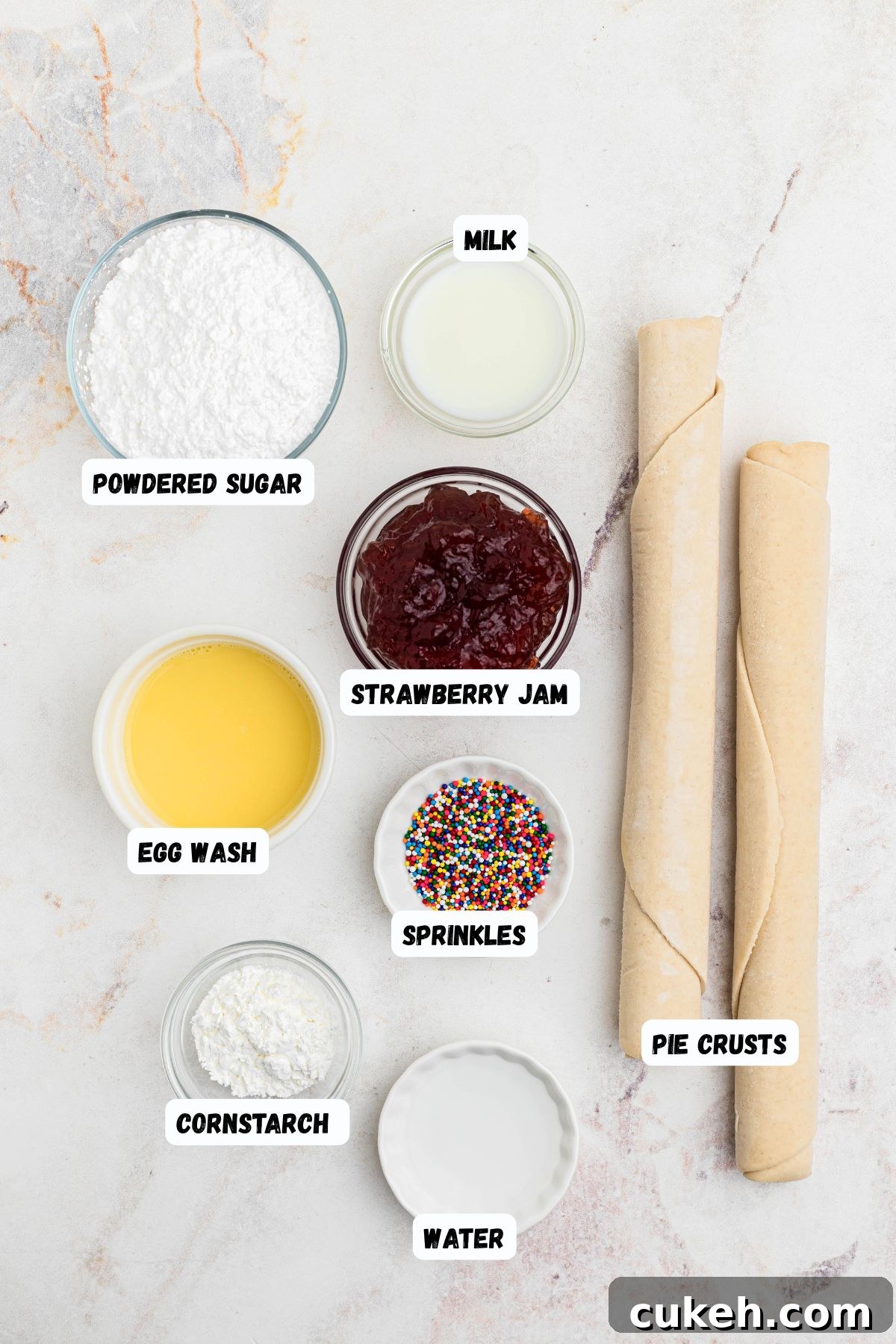 Ingredients needed to make homemade pop tarts on a marble table, and labeled. 