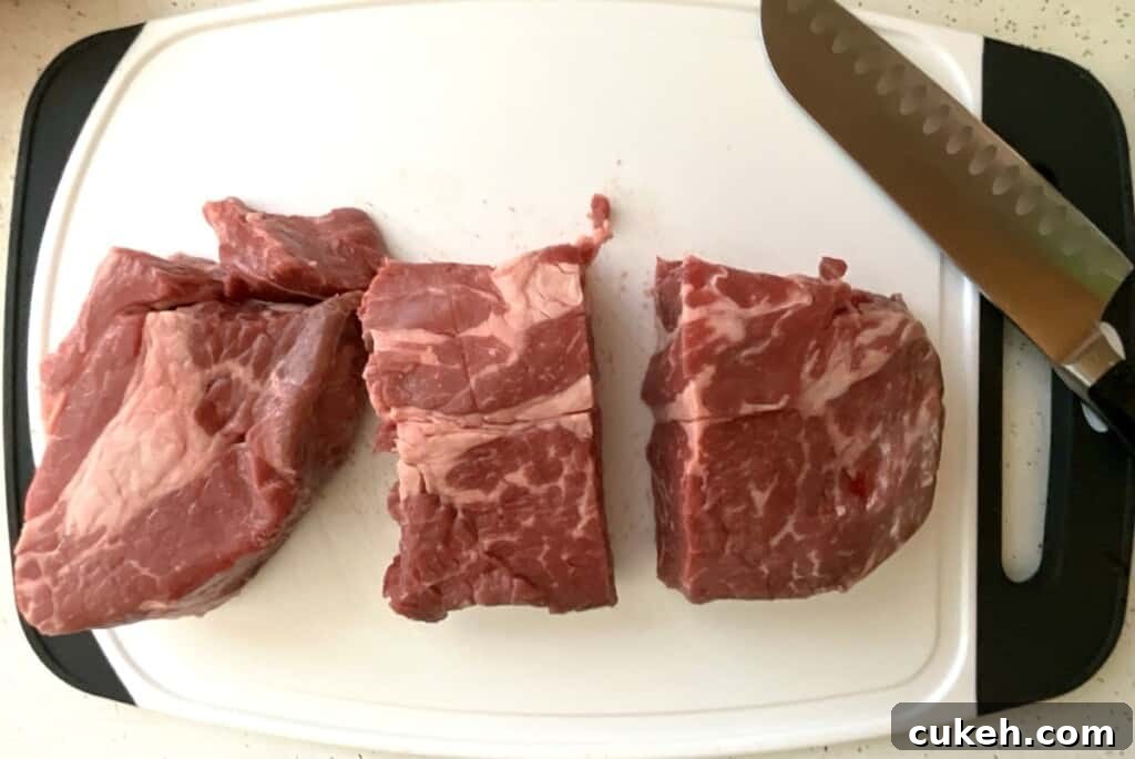 Preparing Chuck Roast Step 1. Cutting into large separate pieces to make instant pot Mississippi roast.