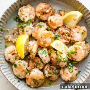 Garlic Butter Shrimp In a Dish with parsley and lemon.
