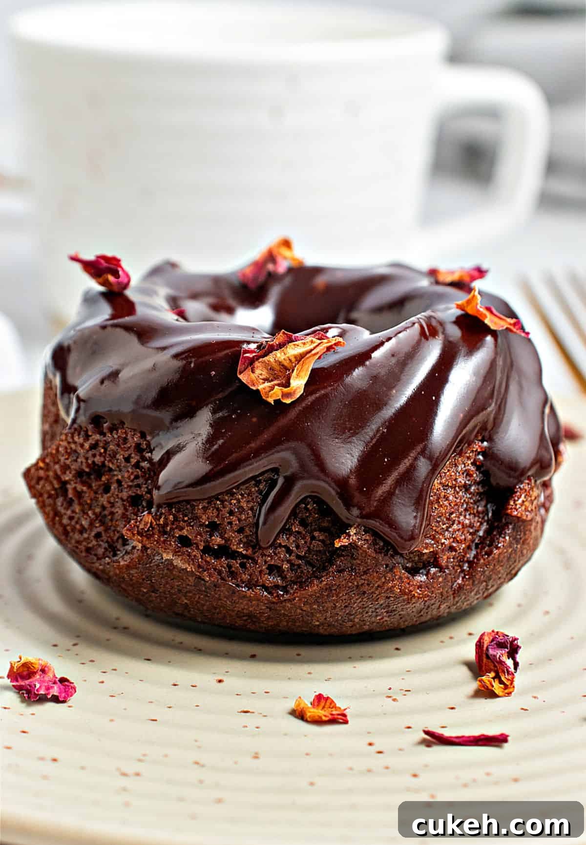 Mini Chocolate Bundt Cakes with Chocolate Glaze 2 Single glazed chocolate small bundt cake on a greenish plate. Rose petals.