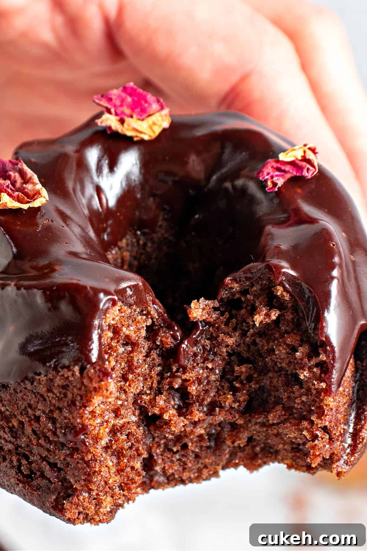 Mini Chocolate Bundt Cakes with Chocolate Glaze 11 Bitten glazed mini chocolate bundt cake being held.