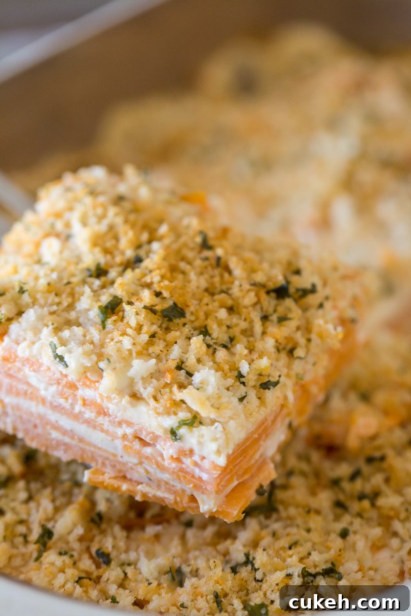 A serving of the Smoked Chili Sweet Potato Gratin being taken from the baking dish.