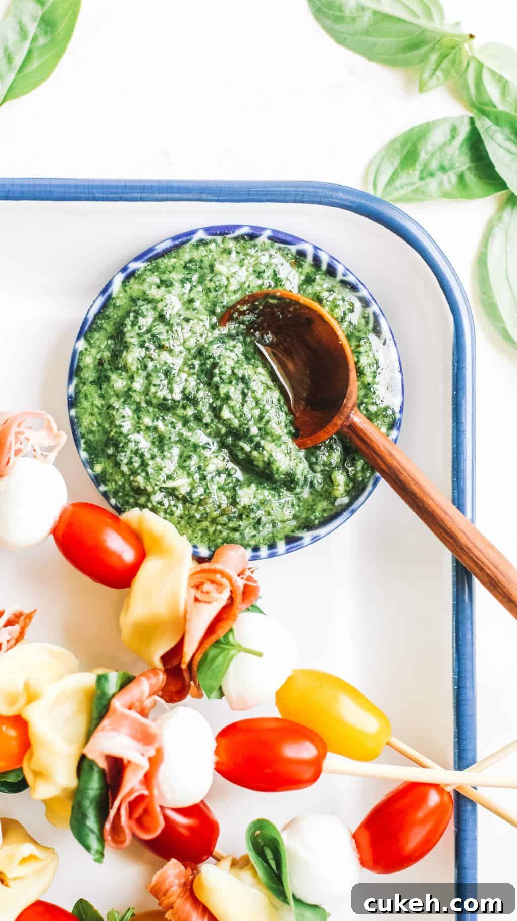 Pesto in a blue bowl with a wooden spoon