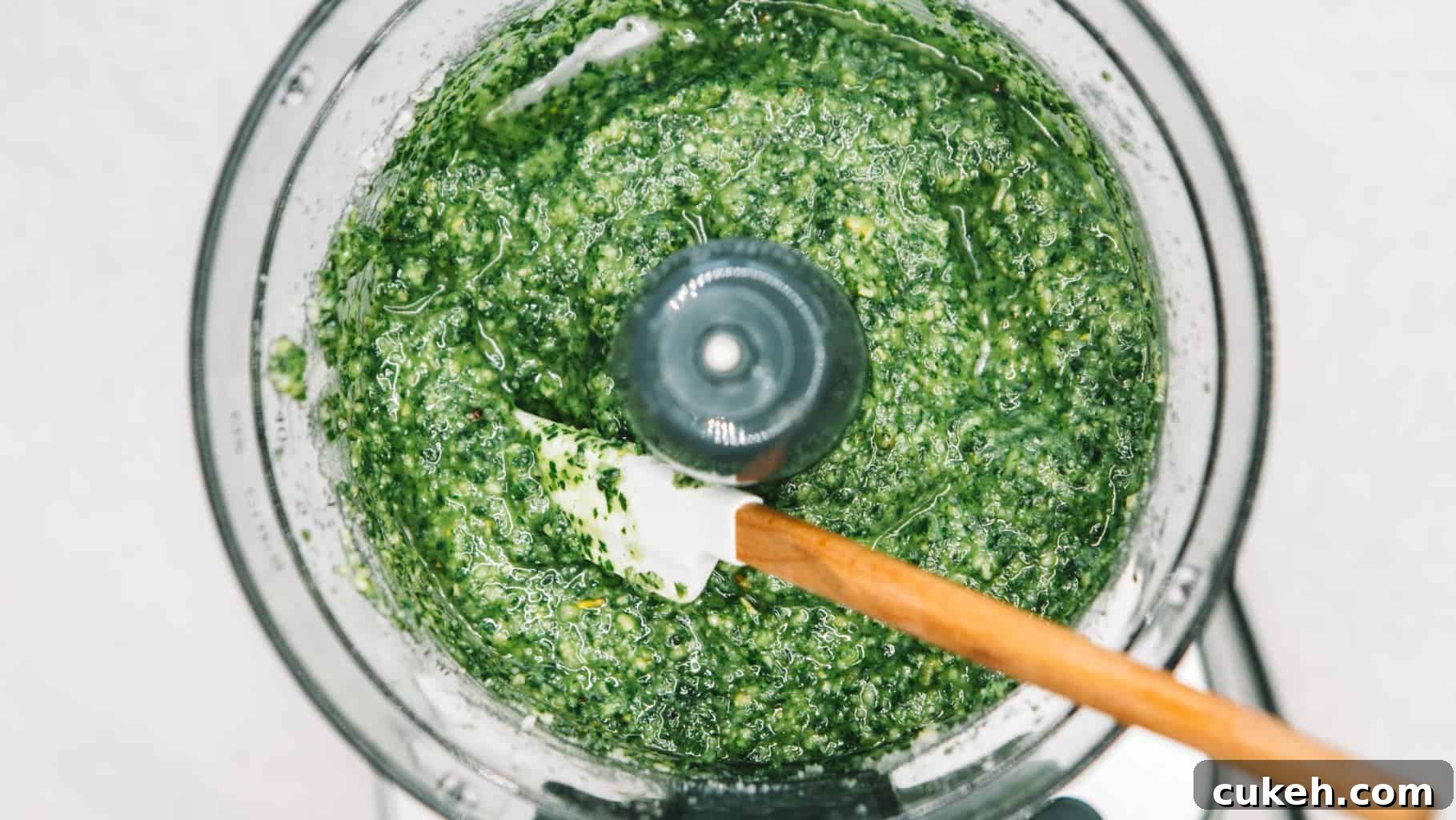 Pesto sauce in the bowl of a food processor with a spatula