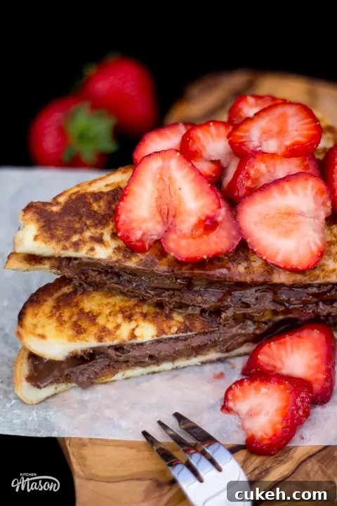 Strawberry Nutella French toast sliced in half with a fork to the side.
