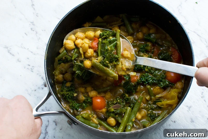 20-Minute Coconut Chickpea Curry with Spinach and Tomato 6 A pan of 20-minute coconut chickpea curry with a serving spoon in it from above