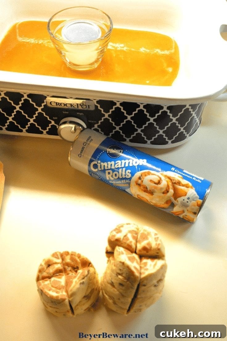 Quarter the cinnamon rolls and layer them in the crock pot, then pour the caramel sauce over the pieces.