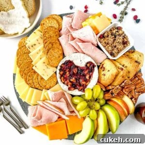 thanksgiving charcuterie board with cheese, crackers, fruits, next to mini forks