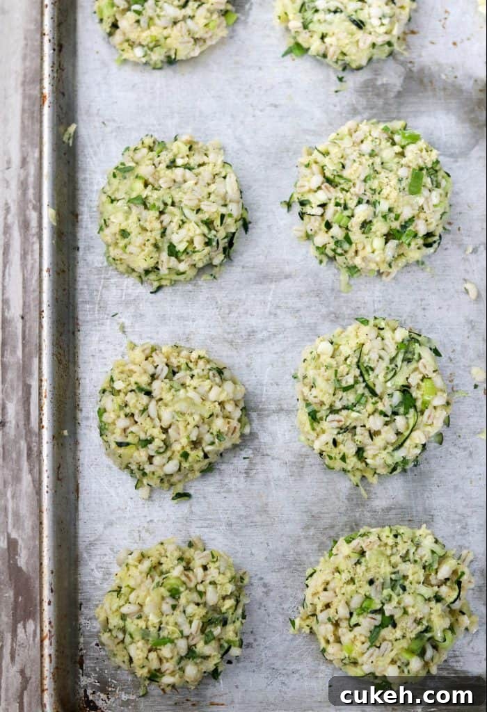 Zucchini and Barley Cakes with Roasted Cherry Tomatoes & Ricotta 5 Uncooked zucchini barley cakes on a sheet pan