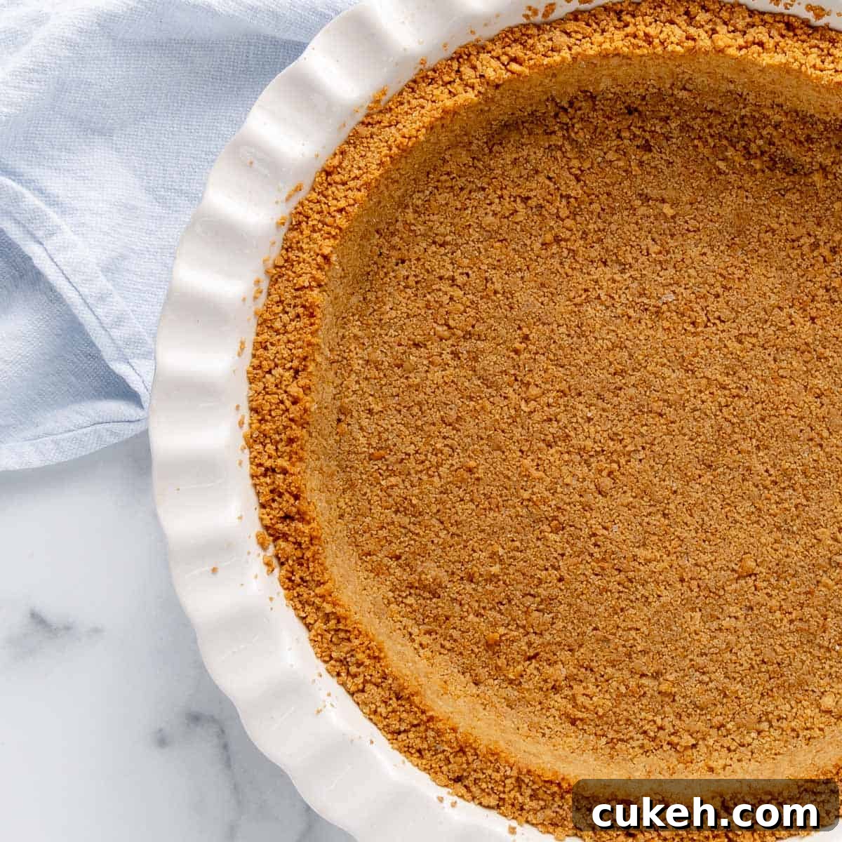 Close up of graham cracker crust in a white pie plate