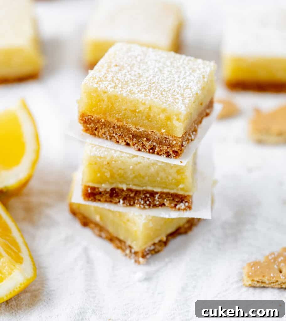 A stack of tangy lemon bars on a graham cracker crust