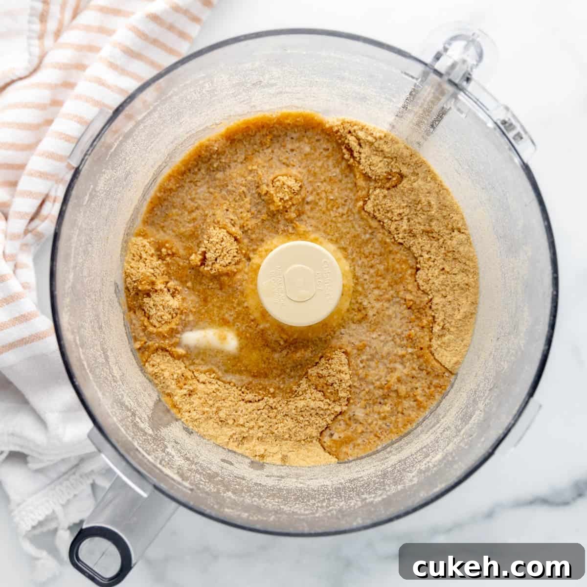 Overhead image of graham cracker crumbs and melted butter on top.