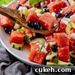 Refreshing Watermelon and Feta Salad with Mint and Balsamic 8 spoon scooping up some watermelon with feta and blueberries