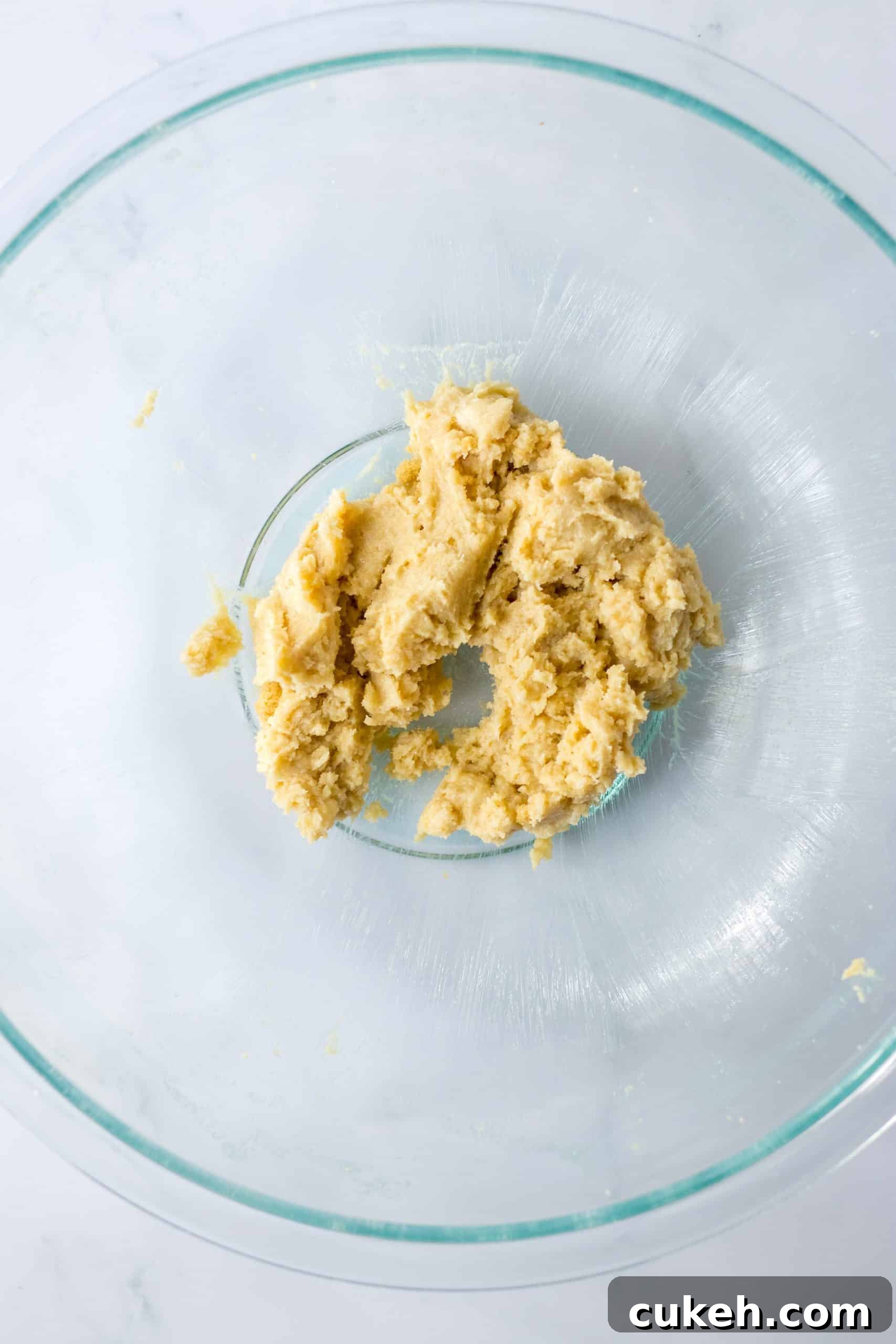 butter and sugars creamed together in a glass mixing bowl