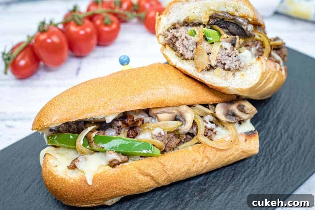 Double halves of Ground Beef Philly Cheesesteak on a slate plate.