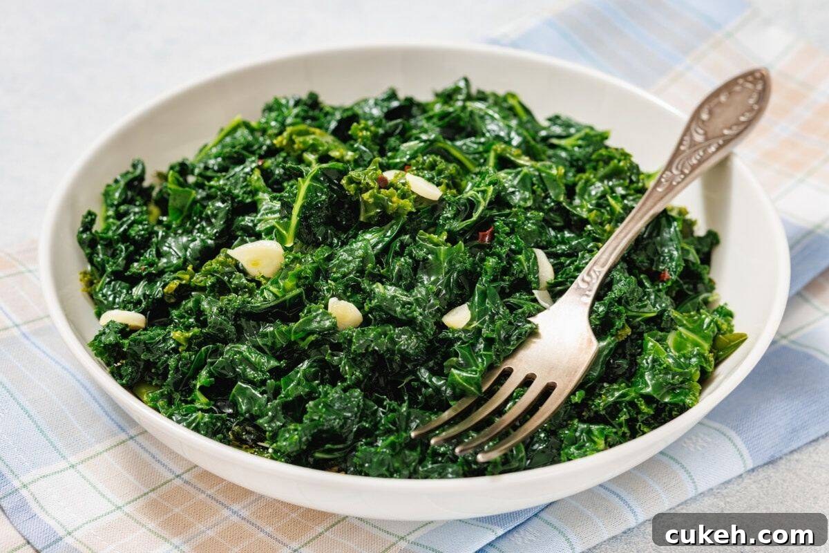 A white bowl filled with Simple Sautéed Kale, with a fork resting on the side.